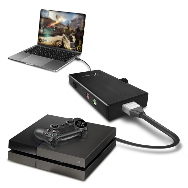 A black HDMI game receiver dongle connected to a PlayStation 4 console and controller, with a laptop shown in the background on a clean white studio background.