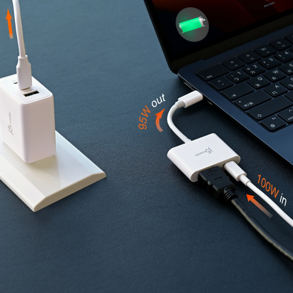 Laptop with power adapter and cable on a dark surface