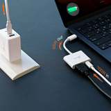 Laptop with power adapter and cable on a dark surface