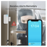 A smart door alarm system shown with a smartphone displaying a notification, a door sensor device, and a person in a hood behind glass. Text reads 'Receive Alerts Remotely' and explains push alert notifications when the door is opened or the sensor is disabled.