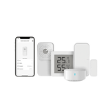 A smart home automation kit featuring a smartphone app control screen, a central digital thermostat showing 25.1°C and 55%, a round white smart bulb, a white motion detector, and two white wall sensors, all arranged on a plain white background.