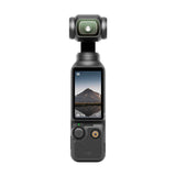 A DJI handheld gimbal camera in dark gray, featuring a built-in screen that displays a mountain landscape, set against a solid white background.