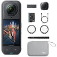 Insta360 action camera shown with included accessories on a white background: a black camera body with a wide-angle lens and screen, a battery, charger cable, protective lens filters, pen-like accessory, and a gray carrying case. The camera screen displays a colorful city selfie.