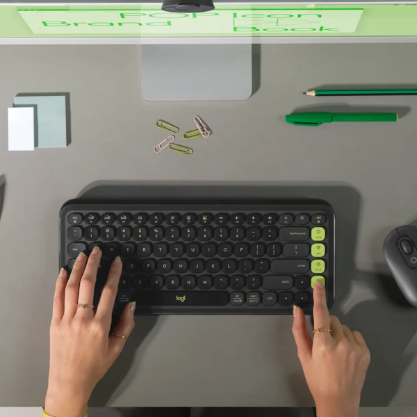 Logitech POP Icon Wireless Keyboard ENOnly and Mouse Combo
Top-down view of a person typing on a Logitech wireless keyboard with lime green accents on a gray desk, with hands, phone, sticky notes, paper clips, pencil, and mouse visible.