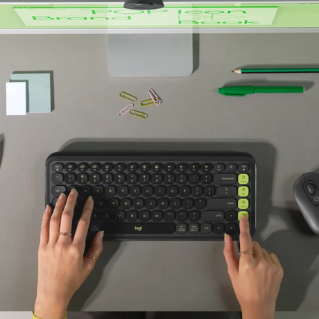 Logitech POP Icon Wireless Keyboard ENOnly and Mouse Combo
Top-down view of a person typing on a Logitech wireless keyboard with lime green accents on a gray desk, with hands, phone, sticky notes, paper clips, pencil, and mouse visible.