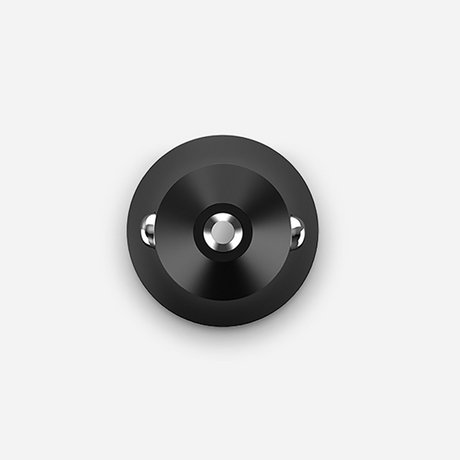 A circular black wall hook with a brushed metal center and two small silver side studs, shown against a light gray background.
