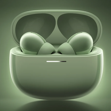 A pair of wireless earbuds inside an open charging case, shown in a matching light sage green color with a soft glowing background.