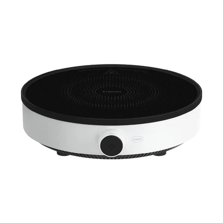 Portable electric hot plate with black surface and silver base on a white background