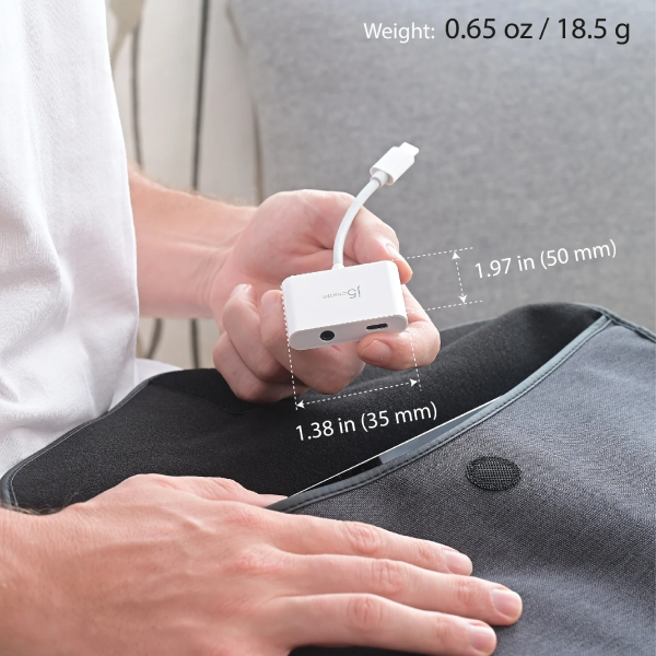 A person holds a small white electronic device with a cable while sitting on a dark gray cushion, with overlaid dimensions and weight text on a light gray background.