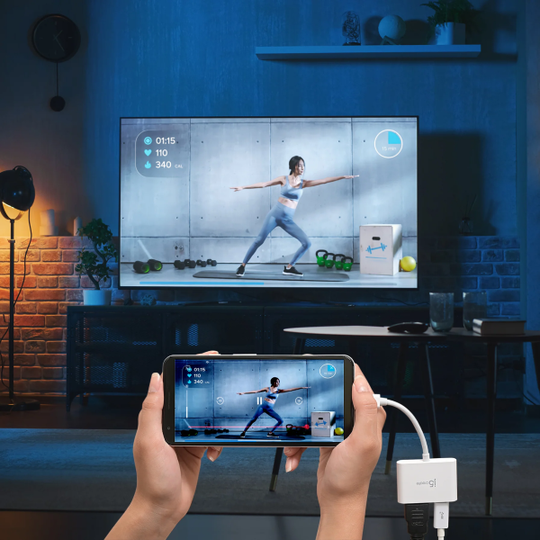 Person using a smartphone with a screen mirroring app to display a fitness app on a TV in a living room.