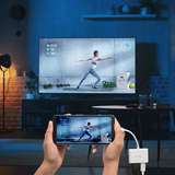 Person using a smartphone with a screen mirroring app to display a fitness app on a TV in a living room.
