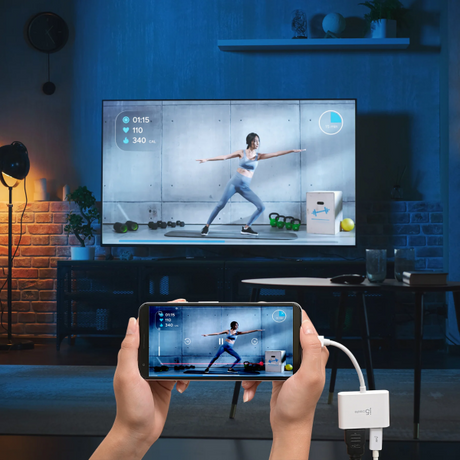 Person using a smartphone with a screen mirroring app to display a fitness app on a TV in a living room.