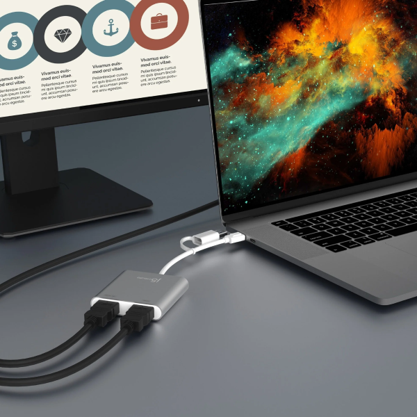 Laptop with a USB-C hub connected to a monitor displaying a colorful screen.