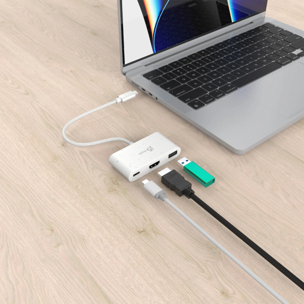 Laptop with a USB hub and cables on a wooden surface