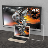 j5create JCC153G USB-C to 4K HDMI Cable - DokkanTech A 4K monitor displaying a futuristic spaceship scene, shown connected to a laptop on a dark wood surface against a light gray wall.