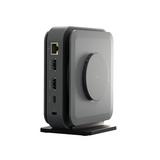 A sleek, dark gray and black electronic device with a circular front panel and side ports, standing on a matching base against a solid white background.