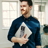 Man holding a laptop in an office setting