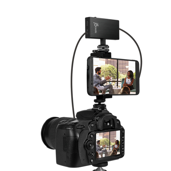 A black camera monitor extension and wireless remote attachment shown mounted on a DSLR camera, with a phone screen attached above the camera to display a video call scene, on a plain white background.