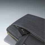 A dark gray fabric laptop sleeve with gold-tone zippers, shown holding a black JSDigital USB drive, photographed on a clean gray gradient background.