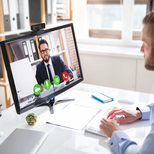 j5create JVCU100 USB HD Webcam with 360° Rotation - DokkanTech Person on a video call with a colleague at a desk in an office setting