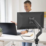 j5create JTSA101 Ergonomic Monitor Mount Support 17 inches to 32inches monitors weighing up to 8kg - 20000 tested stability - DokkanTechBlack Man using a computer setup with a monitor on an adjustable arm at a desk.
