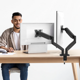 Person using a computer with a monitor arm on a desk