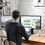 Person working at a desk with multiple computer monitors in a home office setting.