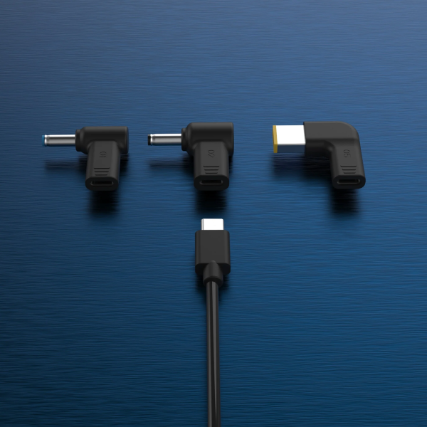 Four black angled USB-C to USB-C adapter plugs arranged on a textured blue background, with one adapter shown attached to a black cable at the bottom.