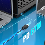 Laptop, smartphone, and keyboard on a reflective surface with a USB cable and 'PD 67W' text.